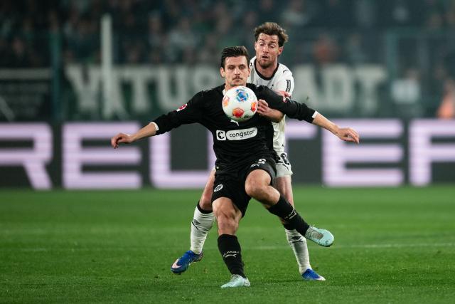 13 March 2026, North Rhine-Westphalia, Moenchengladbach: Gladbach's Joe Scally and and Pauli's Adam Dzwigala in action during the German Bundesliga soccer match between Borussia Moenchengladbach and FC St. Pauli at the Borussia-Park Stadium. Photo: Marius Becker/dpa - IMPORTANT NOTICE: DFL and DFB regulations prohibit any use of photographs as image sequences and/or quasi-video.