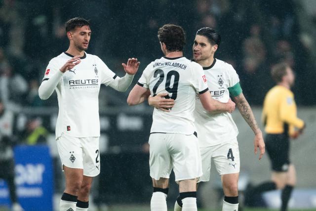 13 March 2026, North Rhine-Westphalia, Moenchengladbach: Gladbach's Fabio Chiarodia, Joe Scally and Kevin Diks celebrate after the German Bundesliga soccer match between Borussia Moenchengladbach and FC St. Pauli at the Borussia-Park Stadium. Photo: Marius Becker/dpa - IMPORTANT NOTICE: DFL and DFB regulations prohibit any use of photographs as image sequences and/or quasi-video.