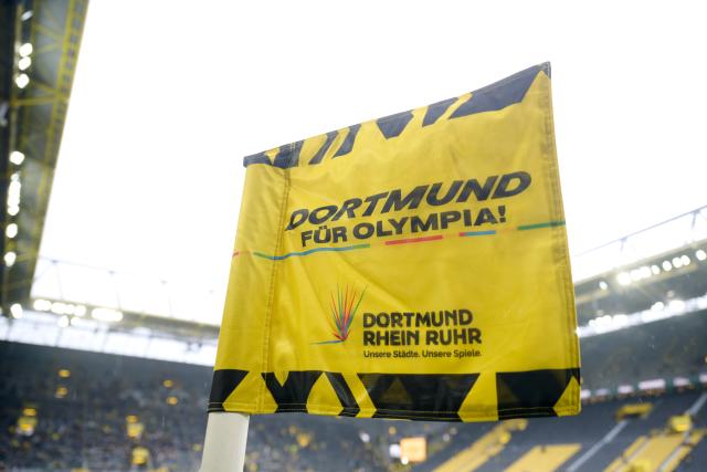 14 March 2026, North Rhine-Westphalia, Dortmund: The corner flag features an advertisement for the Rhein-Ruhr Olympic bid ahead of the German Bundesliga soccer match between Borussia Dortmund and FC Augsburg at Signal Iduna Park. Photo: Bernd Thissen/dpa - WICHTIGER HINWEIS: Gemäß den Vorgaben der DFL Deutsche Fußball Liga bzw. des DFB Deutscher Fußball-Bund ist es untersagt, in dem Stadion und/oder vom Spiel angefertigte Fotoaufnahmen in Form von Sequenzbildern und/oder videoähnlichen Fotostrecken zu verwerten bzw. verwerten zu lassen.