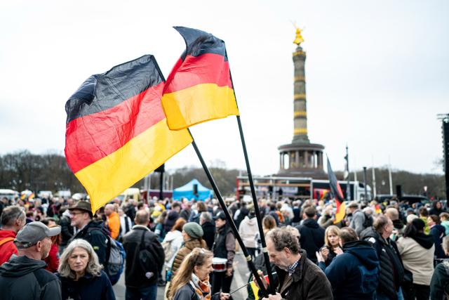14 March 2026, Berlin: Participants at the "Transparency, Rule of Law, and Protection of Minors" demonstration hold an upside-down German flag while calling for "an investigation into possible German connections to the international Epstein scandal." Photo: Fabian Sommer/dpa
