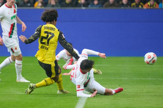 14 March 2026, North Rhine-Westphalia, Dortmund: Borussia Dortmund's Karim Adeyemi scores his side's first goal past Augsburg's Dimitris Giannoulis during the German Bundesliga soccer match between Borussia Dortmund and FC Augsburg at Signal Iduna Park. Photo: Bernd Thissen/dpa - IMPORTANT NOTICE: DFL and DFB regulations prohibit any use of photographs as image sequences and/or quasi-video.