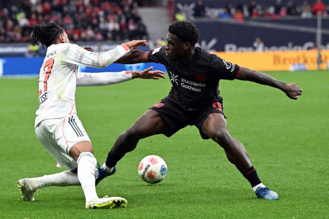 14 March 2026, Leverkusen: Leverkusen's Bayer (R) and Munich's Michael Olise battle for the ball during the German Bundesliga soccer match between Bayer 04 Leverkusen and FC Bayern Munich at the BayArena. Photo: Federico Gambarini/dpa - IMPORTANT NOTICE: DFL and DFB regulations prohibit any use of photographs as image sequences and/or quasi-video.