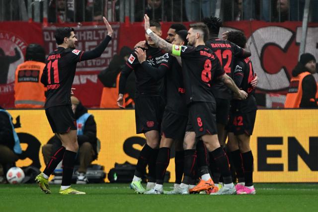 14 March 2026, Leverkusen: Leverkusen players celebrate their first goal during the German Bundesliga soccer match between Bayer 04 Leverkusen and FC Bayern Munich at the BayArena. Photo: Federico Gambarini/dpa - IMPORTANT NOTICE: DFL and DFB regulations prohibit any use of photographs as image sequences and/or quasi-video.