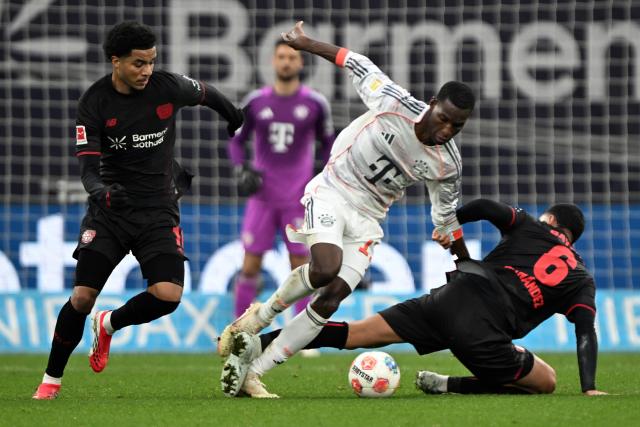 14 March 2026, Leverkusen: Leverkusen's Ezequiel Fernandez (R) and Munich's Nicolas Jackson (C) battle for the ball during the German Bundesliga soccer match between Bayer 04 Leverkusen and FC Bayern Munich at the BayArena. Photo: Federico Gambarini/dpa - IMPORTANT NOTICE: DFL and DFB regulations prohibit any use of photographs as image sequences and/or quasi-video.