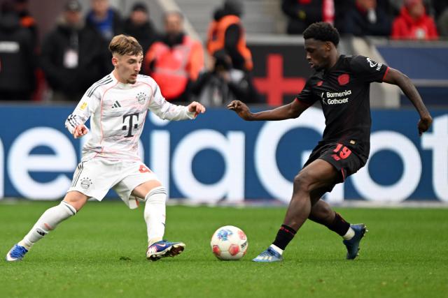 14 March 2026, Leverkusen: Leverkusen's Malik Tillman (R) and Munich's Lennart Karl battle for the ball during the German Bundesliga soccer match between Bayer 04 Leverkusen and FC Bayern Munich at the BayArena. Photo: Federico Gambarini/dpa - IMPORTANT NOTICE: DFL and DFB regulations prohibit any use of photographs as image sequences and/or quasi-video.