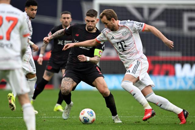 14 March 2026, Leverkusen: Leverkusen's Robert Andrich and Munich's Harry Kane battle for the ball during the German Bundesliga soccer match between Bayer 04 Leverkusen and FC Bayern Munich at the BayArena. Photo: Federico Gambarini/dpa - IMPORTANT NOTICE: DFL and DFB regulations prohibit any use of photographs as image sequences and/or quasi-video.
