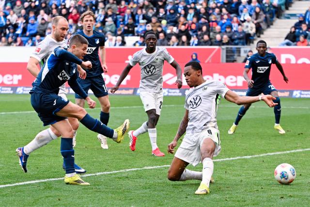 14 March 2026, Baden-Württemberg, Sinsheim: Hoffenheim's Andrej Kramaric (L) and Wolfsburg's Jeanuel Belocian in action during the German Bundesliga soccer match between TSG 1899 Hoffenheim and VfL Wolfsburg at the PreZero Arena. Photo: Uwe Anspach/dpa - IMPORTANT NOTICE: DFL and DFB regulations prohibit any use of photographs as image sequences and/or quasi-video.