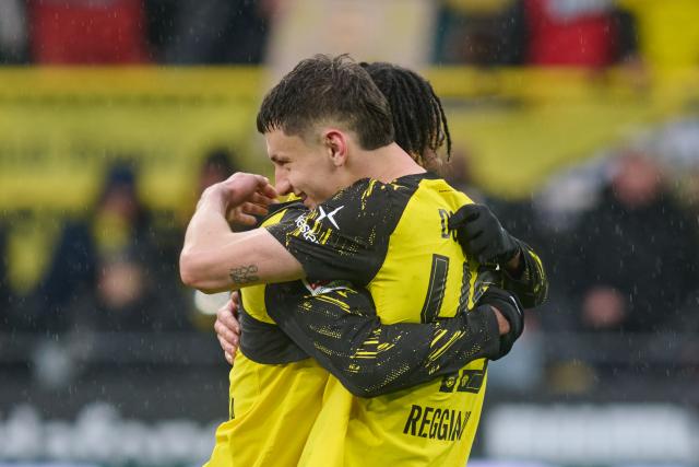 14 March 2026, North Rhine-Westphalia, Dortmund: Dortmund's Luca Reggiani (R) hugs Carney Chukwuemeka after the German Bundesliga soccer match between Borussia Dortmund and FC Augsburg at Signal Iduna Park. Photo: Bernd Thissen/dpa - IMPORTANT NOTICE: DFL and DFB regulations prohibit any use of photographs as image sequences and/or quasi-video.