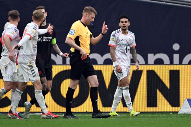 14 March 2026, Leverkusen: Referee Christian Dingert (2nd R) walks after showing Munich's Luis Diaz (R) a yellow-red card during the German Bundesliga soccer match between Bayer 04 Leverkusen and FC Bayern Munich at the BayArena. Photo: Federico Gambarini/dpa - IMPORTANT NOTICE: DFL and DFB regulations prohibit any use of photographs as image sequences and/or quasi-video.