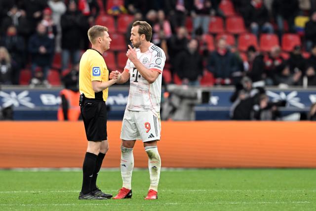 14 March 2026, Leverkusen: Referee Christian Dingert (L) and Bayern Munich's Harry Kane speak on the pitch during the German Bundesliga soccer match between Bayer 04 Leverkusen and FC Bayern Munich at the BayArena. Photo: Federico Gambarini/dpa - IMPORTANT NOTICE: DFL and DFB regulations prohibit any use of photographs as image sequences and/or quasi-video.