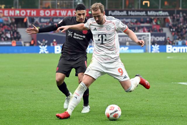 14 March 2026, Leverkusen: Leverkusen's Ezequiel Fernandez (L) and Munich's Harry Kane battle for the ball during the German Bundesliga soccer match between Bayer 04 Leverkusen and FC Bayern Munich at the BayArena. Photo: Federico Gambarini/dpa - IMPORTANT NOTICE: DFL and DFB regulations prohibit any use of photographs as image sequences and/or quasi-video.