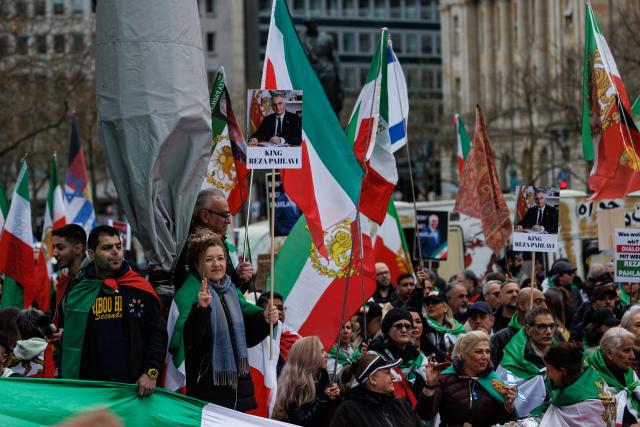 14 March 2026, Hesse, Frankfurt/Main: Participants hold flags of the Iranian monarchy at the "Peaceful Demonstration and Elevation for Freedom and Democracy in Iran" demonstration in Frankfurt. Photo: Hannes P Albert/dpa