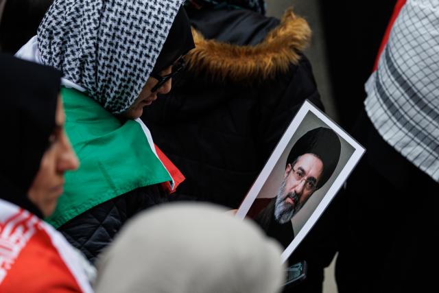 14 March 2026, Hesse, Frankfurt/Main: A participant holds a picture of the new Supreme Leader of Iran, Mojtaba Khamenei during the "Stop Zionism - Solidarity with Palestine & Iran" demonstration. Photo: Hannes P Albert/dpa