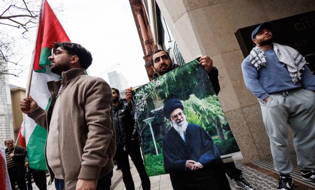 14 March 2026, Hesse, Frankfurt/Main: A participant holds a picture of slain Iranian Supreme leader Ali Khamenei during the "Stop Zionism - Solidarity with Palestine & Iran" demonstration. Photo: Hannes P Albert/dpa