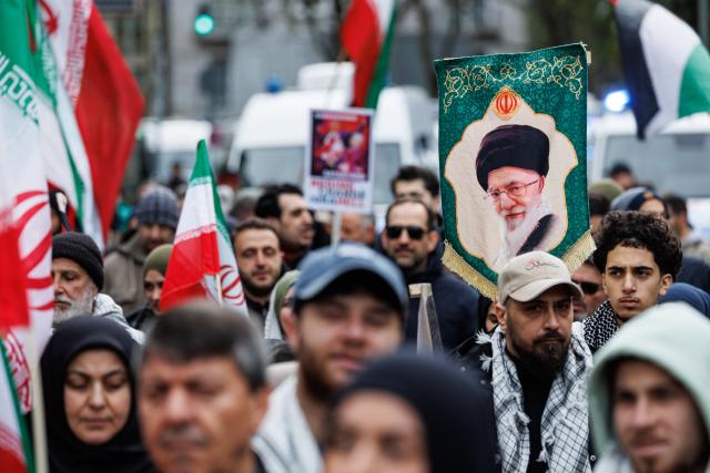 14 March 2026, Hesse, Frankfurt/Main: A participant holds a picture of slain Iranian Supreme leader Ali Khamenei during the "Stop Zionism - Solidarity with Palestine & Iran" demonstration. Photo: Hannes P. Albert/dpa