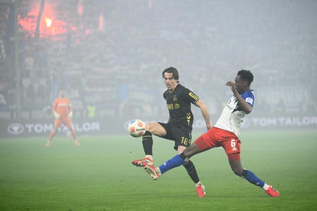 14 March 2026, Hamburg: Cologne's Jakub Kaminski and Hamburger's Albert Lokonga battle for the ball during the German Bundesliga soccer match between Hamburger SV and 1. FC Cologne at the Volksparkstadion. Photo: Gregor Fischer/dpa - IMPORTANT NOTICE: DFL and DFB regulations prohibit any use of photographs as image sequences and/or quasi-video.