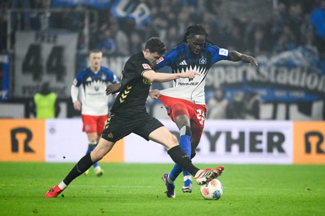 14 March 2026, Hamburg: Cologne's Rav van den Berg and Hamburger's Jordan Torunarigha battle for the ball during the German Bundesliga soccer match between Hamburger SV and 1. FC Cologne at the Volksparkstadion. Photo: Gregor Fischer/dpa - IMPORTANT NOTICE: DFL and DFB regulations prohibit any use of photographs as image sequences and/or quasi-video.