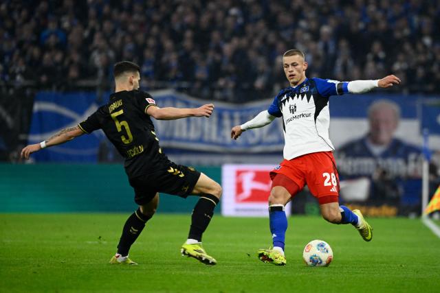 14 March 2026, Hamburg: Cologne's Tom Krauss and Hamburger's Miro Muheim battle for the ball during the German Bundesliga soccer match between Hamburger SV and 1. FC Cologne at the Volksparkstadion. Photo: Gregor Fischer/dpa - IMPORTANT NOTICE: DFL and DFB regulations prohibit any use of photographs as image sequences and/or quasi-video.