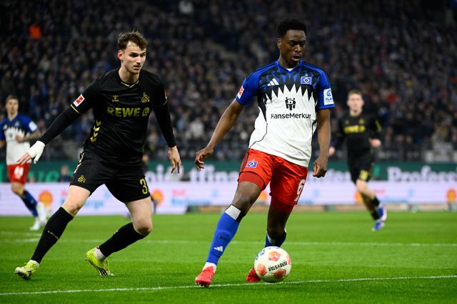 14 March 2026, Hamburg: Cologne's Rav van den Berg and Hamburger's Albert Lokonga battle for the ball during the German Bundesliga soccer match between Hamburger SV and 1. FC Cologne at the Volksparkstadion. Photo: Gregor Fischer/dpa - IMPORTANT NOTICE: DFL and DFB regulations prohibit any use of photographs as image sequences and/or quasi-video.