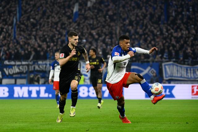 14 March 2026, Hamburg: Cologne's Tom Krauss and Hamburger's Ransford Koenigsdoerffer battle for the ball during the German Bundesliga soccer match between Hamburger SV and 1. FC Cologne at the Volksparkstadion. Photo: Gregor Fischer/dpa - IMPORTANT NOTICE: DFL and DFB regulations prohibit any use of photographs as image sequences and/or quasi-video.