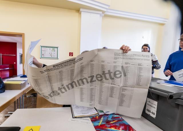 15 March 2026, Hesse, Frankfurt/Main: A sample ballot paper is held up in constituency 680, Saalbau Volkshaus Enkheim. Almost 4.7 million citizens can once again vote for their municipal and district parliaments in the local elections in Hesse. According to the state electoral administration, it is about the mandates in the 21 district parliaments and the municipal parliaments of 421 cities and municipalities. Photo: Andreas Arnold/dpa