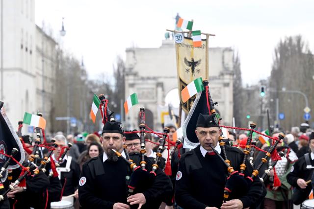 15 March 2026, Bavaria, Munich: Bagpipers, participants in the St. Patrick's Day parade, pass the Siegestor on their way from Muenchner Freiheit to Odeonsplatz. The parade in Munich in honor of the Irish national saint is celebrating its 30th anniversary this year. Photo: Felix Hörhager/dpa
