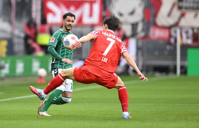 15 March 2026, Bremen: Werder Bremen's Leonardo Bittencourt (L) and Mainz's Jae-sung Lee battle for the ball during the German Bundesliga soccer match between Werder Bremen and FSV Mainz 05 at Weserstadion. Photo: Carmen Jaspersen/dpa - WICHTIGER HINWEIS: Gemäß den Vorgaben der DFL Deutsche Fußball Liga bzw. des DFB Deutscher Fußball-Bund ist es untersagt, in dem Stadion und/oder vom Spiel angefertigte Fotoaufnahmen in Form von Sequenzbildern und/oder videoähnlichen Fotostrecken zu verwerten bzw. verwerten zu lassen.