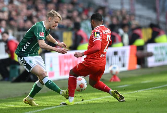15 March 2026, Bremen: Werder Bremen's Marco Gruell  (L) and Mainz's Phillipp Mwene battle for the ball during the German Bundesliga soccer match between Werder Bremen and FSV Mainz 05 at Weserstadion. Photo: Carmen Jaspersen/dpa - WICHTIGER HINWEIS: Gemäß den Vorgaben der DFL Deutsche Fußball Liga bzw. des DFB Deutscher Fußball-Bund ist es untersagt, in dem Stadion und/oder vom Spiel angefertigte Fotoaufnahmen in Form von Sequenzbildern und/oder videoähnlichen Fotostrecken zu verwerten bzw. verwerten zu lassen.