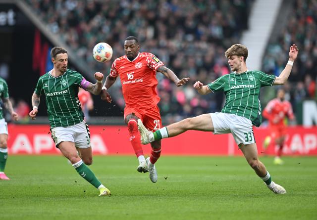 15 March 2026, Bremen: Mainz's Sheraldo Becker (C) battles for the ball with Werder Bremen's Marco Friedl (L) and Mick Schmetgens during the German Bundesliga soccer match between Werder Bremen and FSV Mainz 05 at Weserstadion. Photo: Carmen Jaspersen/dpa - WICHTIGER HINWEIS: Gemäß den Vorgaben der DFL Deutsche Fußball Liga bzw. des DFB Deutscher Fußball-Bund ist es untersagt, in dem Stadion und/oder vom Spiel angefertigte Fotoaufnahmen in Form von Sequenzbildern und/oder videoähnlichen Fotostrecken zu verwerten bzw. verwerten zu lassen.