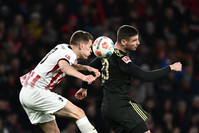 15 March 2026, Baden-Wuerttemberg, Freiburg im Breisgau: Freiburg's Matthias Ginter (L) and Union Berlin's Andrej Ilic battle for the ball during the German Bundesliga soccer match between SC Freiburg and 1. FC Union Berlin at Europa-Park Stadium. Photo: Silas Stein/dpa - WICHTIGER HINWEIS: Gemäß den Vorgaben der DFL Deutsche Fußball Liga bzw. des DFB Deutscher Fußball-Bund ist es untersagt, in dem Stadion und/oder vom Spiel angefertigte Fotoaufnahmen in Form von Sequenzbildern und/oder videoähnlichen Fotostrecken zu verwerten bzw. verwerten zu lassen.