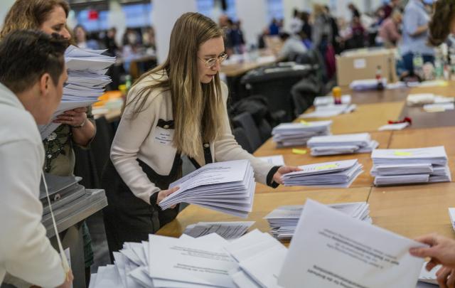15 March 2026, Hesse, Frankfurt/Main: People count ballots at the mail-in voting center in the exhibition halls for the local elections in Hesse. Photo: Andreas Arnold/dpa