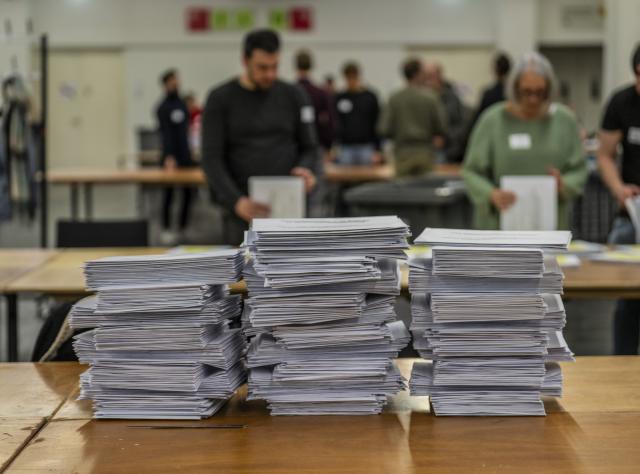 15 March 2026, Hesse, Frankfurt/Main: People count ballots at the mail-in voting center in the exhibition halls for the local elections in Hesse. Photo: Andreas Arnold/dpa