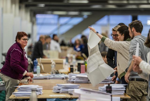 15 March 2026, Hesse, Frankfurt/Main: People count ballots at the mail-in voting center in the exhibition halls for the local elections in Hesse. Photo: Andreas Arnold/dpa