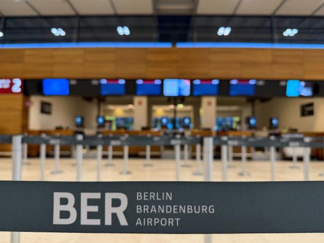 18 March 2026, Brandenburg, Schoenefeld: Barricade tape bearing the words 'BER Berlin Brandenburg Airport' is strung across a terminal at Berlin Brandenburg Airport (BER). Due to a warning strike by the Verdi union, no passenger flights take off or land at BER, with all departures and arrivals cancelled for the entire day, as previously announced by the airport operator. Photo: Julian Dengler/dpa