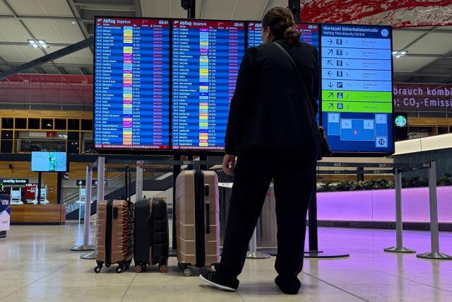 18 March 2026, Brandenburg, Schoenefeld: A man stands in the lobby of Berlin Brandenburg Airport (BER) in front of an information board displaying that all flights are cancelled Due to a warning strike by the Verdi union, no passenger planes take off or land at BER, with all departures and arrivals cancelled for the entire day, as previously announced by the airport operator. Photo: Antonia Sawallisch/dpa