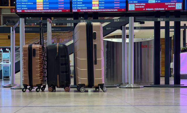 18 March 2026, Brandenburg, Schoenefeld: Three suitcases stand abandoned in the lobby of Berlin Brandenburg Airport (BER). Due to a warning strike by the Verdi union, no passenger planes take off or land at BER, with all departures and arrivals canceled for the entire day, as previously announced by the airport operator. Photo: Antonia Sawallisch/dpa