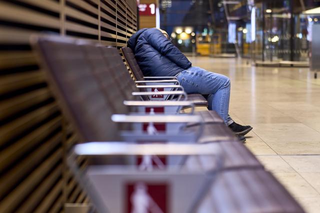 18 March 2026, Brandenburg, Schoenefeld: A lone traveler sits on a bench in Terminal 1 at Berlin Brandenburg Airport (BER), waiting. Due to a warning strike by the Verdi union, no passenger flights take off or land at BER, with all departures and arrivals canceled for the entire day, as previously announced by the airport operator. Photo: Michael Ukas/dpa