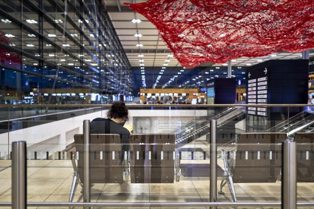18 March 2026, Brandenburg, Schoenefeld: A lone traveler sits on a bench in Terminal 1 at Berlin Brandenburg Airport (BER), waiting. Due to a warning strike by the Verdi union, no passenger flights take off or land at BER, with all departures and arrivals canceled for the entire day, as previously announced by the airport operator. Photo: Michael Ukas/dpa