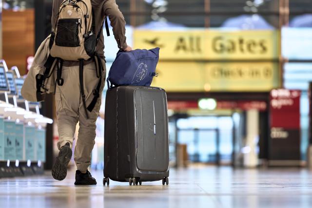 18 March 2026, Brandenburg, Schoenefeld: A few travelers walk through Terminal 1 at Berlin Brandenburg Airport (BER). Due to a warning strike by the Verdi union, no passenger flights take off or land at BER, with all departures and arrivals canceled for the entire day, as previously announced by the airport operator. Photo: Michael Ukas/dpa