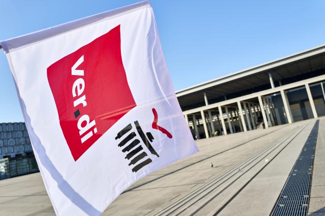18 March 2026, Brandenburg, Schoenefeld: Striking airport employees and Verdi union members stand in front of the terminal during a warning strike at Berlin Brandenburg Airport (BER), halting all operations. No passenger flights have taken off or landed at BER since this morning, with all departures and arrivals cancelled for the entire day, the Berlin-Brandenburg Airport Company (FBB) had announced. Photo: Michael Ukas/dpa