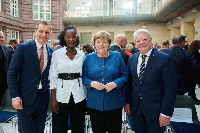 18 March 2026, Berlin: (L-R) Michael Mronz, Former partner of Free Democratic Party (FDP) politician Guido Westerwelle, founder of Bena Care in Nigeria Naom Monari, former Chancellor Angela Merkel and former President Joachim Gauck stand after the memorial service marking the 10th anniversary of the FDP politician's death. Photo: Annette Riedl/dpa