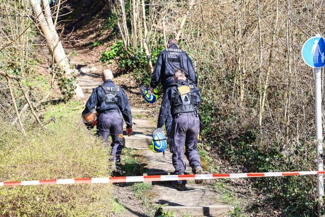 18 March 2026, North Rhine-Westphalia, Witten: Police officers conduct a large-scale search operation in a wooded area cordoned off with caution tape. Authorities are seeking additional evidence in the case of a woman from Bochum who is believed to have been killed. Photo: Alex Talash/dpa