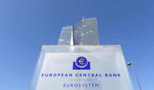 FILED - 07 September 2016, Hesse, Frankfurt_Main: The headquarters of the European Central Bank (ECB) in Frankfurt am Main protrudes from behind a stele with the ECB logo. The European Central Bank (ECB) is set to announce its latest decision on interest rates on Wednesday against the backdrop of surging oil prices due to the war in the Middle East. Photo: Arne Dedert/dpa