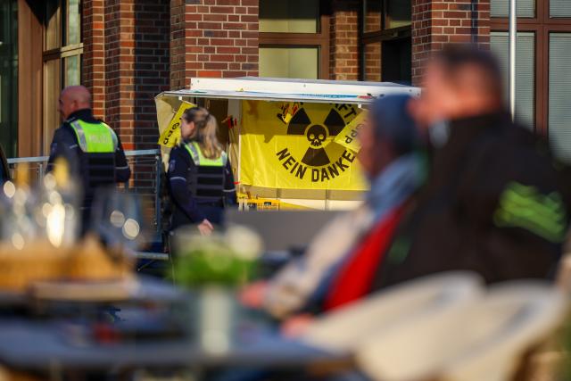 19 March 2026, North Rhine-Westphalia, Ahaus: Two police officers walk past a vigil in front of City Hall before the start of a public forum on the upcoming shipments of nuclear waste from Juelich to Ahaus. Photo: Christoph Reichwein/dpa
