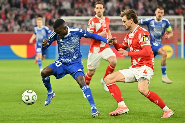 19 March 2026, Rheinland-Pfalz, Mainz: Sigma Olomouc's Ahmad Ghali (L) and Mainz's Stefan Posch battle for the ball during the UEFA Europa Conference League round of 16 second leg soccer match between FSV Mainz 05 and Sigma Olomouc at Mewa Arena. Photo: Torsten Silz/dpa