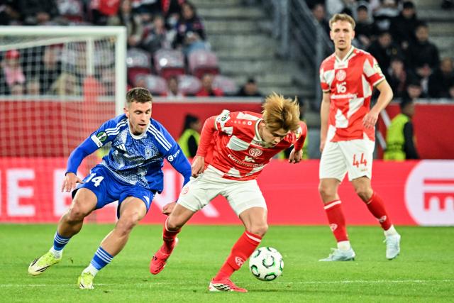 19 March 2026, Rheinland-Pfalz, Mainz: Mainz's Kaishu Sano and Sigma Olomouc's Antonin Rusek (L) battle for the ball during the UEFA Europa Conference League round of 16 second leg soccer match between FSV Mainz 05 and Sigma Olomouc at Mewa Arena. Photo: Torsten Silz/dpa