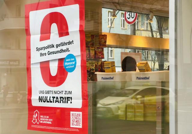 20 March 2026, Berlin: A protest poster with the inscription "Austerity policy endangers your health. We don't come for free!" hangs in the window of a pharmacy. Pharmacies across Germany have called for a day of protest on 23.03.2026 and want to keep their stores closed, supplies are to be provided by emergency service pharmacies and demonstrations have been announced. Photo: Fernando Gutierrez-Juarez/dpa