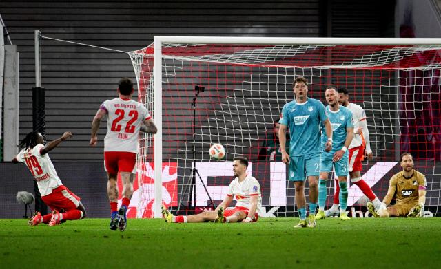 20 March 2026, Saxony, Leipzig: Leipzig's Christoph Baumgartner (C) celebrates scoring his side's third goal, while Yan Diomande (L) runs toward him during the German Bundesliga soccer match between RB Leipzig and TSG 1899 Hoffenheim at Red Bull Arena. Photo: Julius Frick/dpa