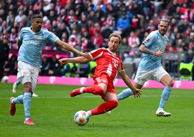 21 March 2026, Bavaria, Munich: Bayern Munich's Harry Kane (L) battle for the ball with Union Berlin's Livan Burcu (L) and Christopher Trimmel during the German Bundesliga soccer match between Bayern Munich and 1. FC Union Berlin at the Allianz Arena. Photo: Sven Hoppe/dpa - WICHTIGER HINWEIS: Gemäß den Vorgaben der DFL Deutsche Fußball Liga bzw. des DFB Deutscher Fußball-Bund ist es untersagt, in dem Stadion und/oder vom Spiel angefertigte Fotoaufnahmen in Form von Sequenzbildern und/oder videoähnlichen Fotostrecken zu verwerten bzw. verwerten zu lassen.