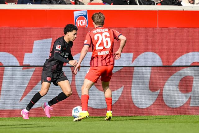 21 March 2026, Baden-Wuerttemberg, Heidenheim: Leverkusen's Montrell Culbreath (L) and Heidenheim's Hennes Behrens battle for the ball during the German Bundesliga soccer match between 1. FC Heidenheim and Bayer Leverkusen at Voith-Arena. Photo: Harry Langer/dpa - WICHTIGER HINWEIS: Gemäß den Vorgaben der DFL Deutsche Fußball Liga bzw. des DFB Deutscher Fußball-Bund ist es untersagt, in dem Stadion und/oder vom Spiel angefertigte Fotoaufnahmen in Form von Sequenzbildern und/oder videoähnlichen Fotostrecken zu verwerten bzw. verwerten zu lassen.